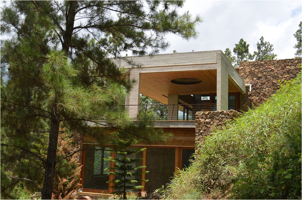 grass roofed home built into slope uses hillside for cooling
